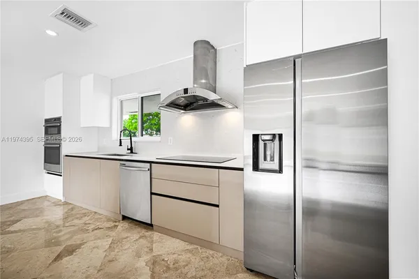 a kitchen with stainless steel appliances kitchen island a refrigerator sink and stove