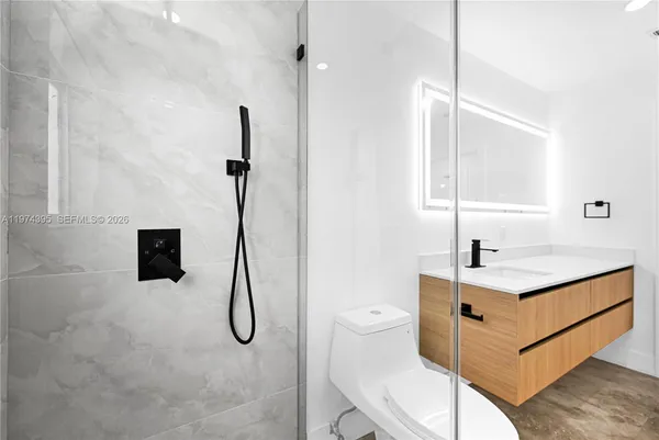 a bathroom with a granite countertop sink a toilet and a mirror