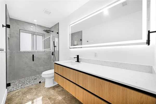 a bathroom with a sink a toilet and shower
