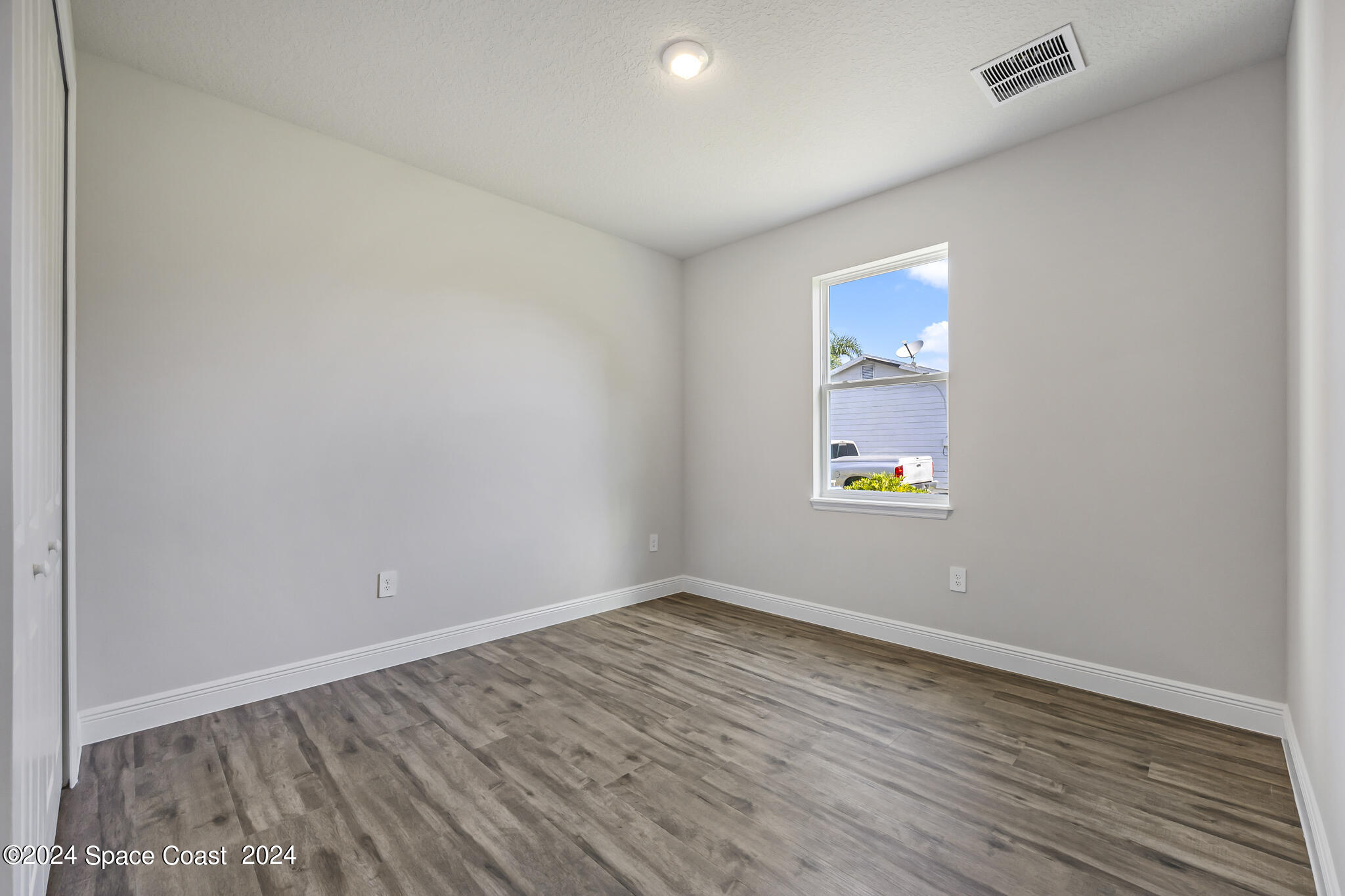 1368 Rabbit Street Southeast Palm Bay, FL 32909 - Photo 22 of 31 an empty room with wooden floor and windows