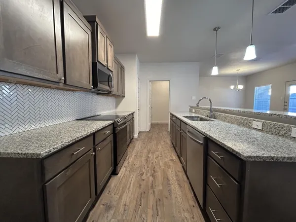 a kitchen with stainless steel appliances granite countertop counter space a sink and cabinets