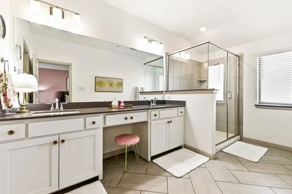 a spacious bathroom with a granite countertop sink a mirror and a shower