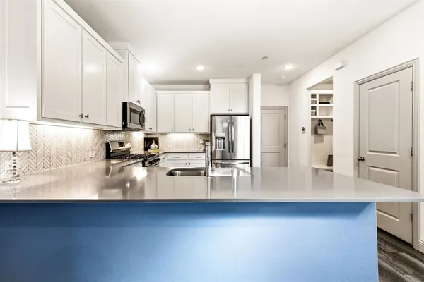 a kitchen with stainless steel appliances sink refrigerator and microwave