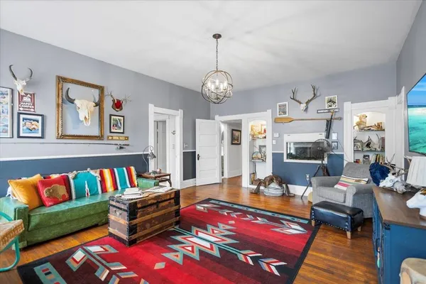 a living room with furniture a rug and a chandelier
