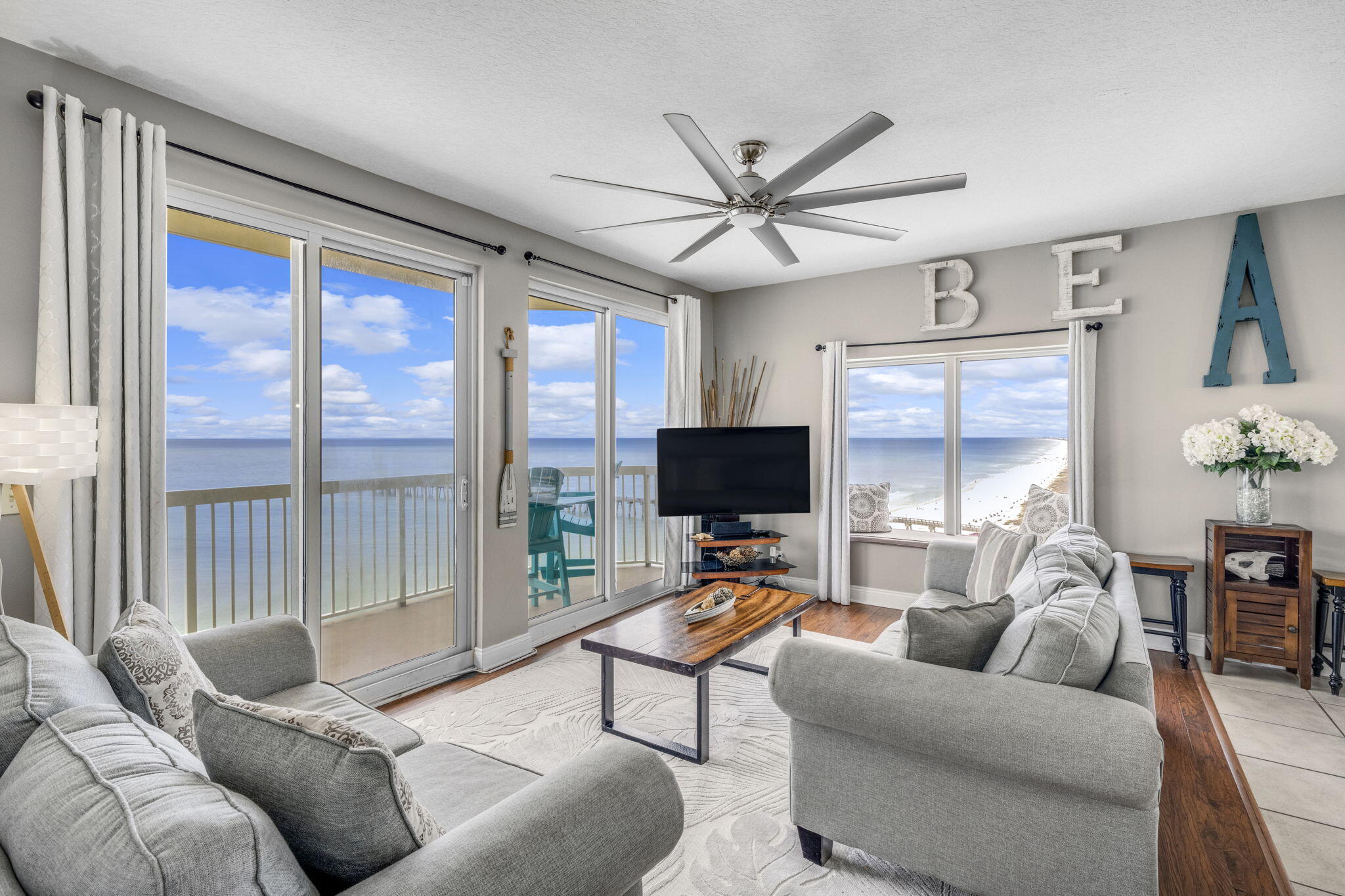 15817 Front Beach Road, Unit 21409 Panama City Beach, FL 32413 - Photo 1 of 23 a living room with furniture a flat screen tv and a large window
