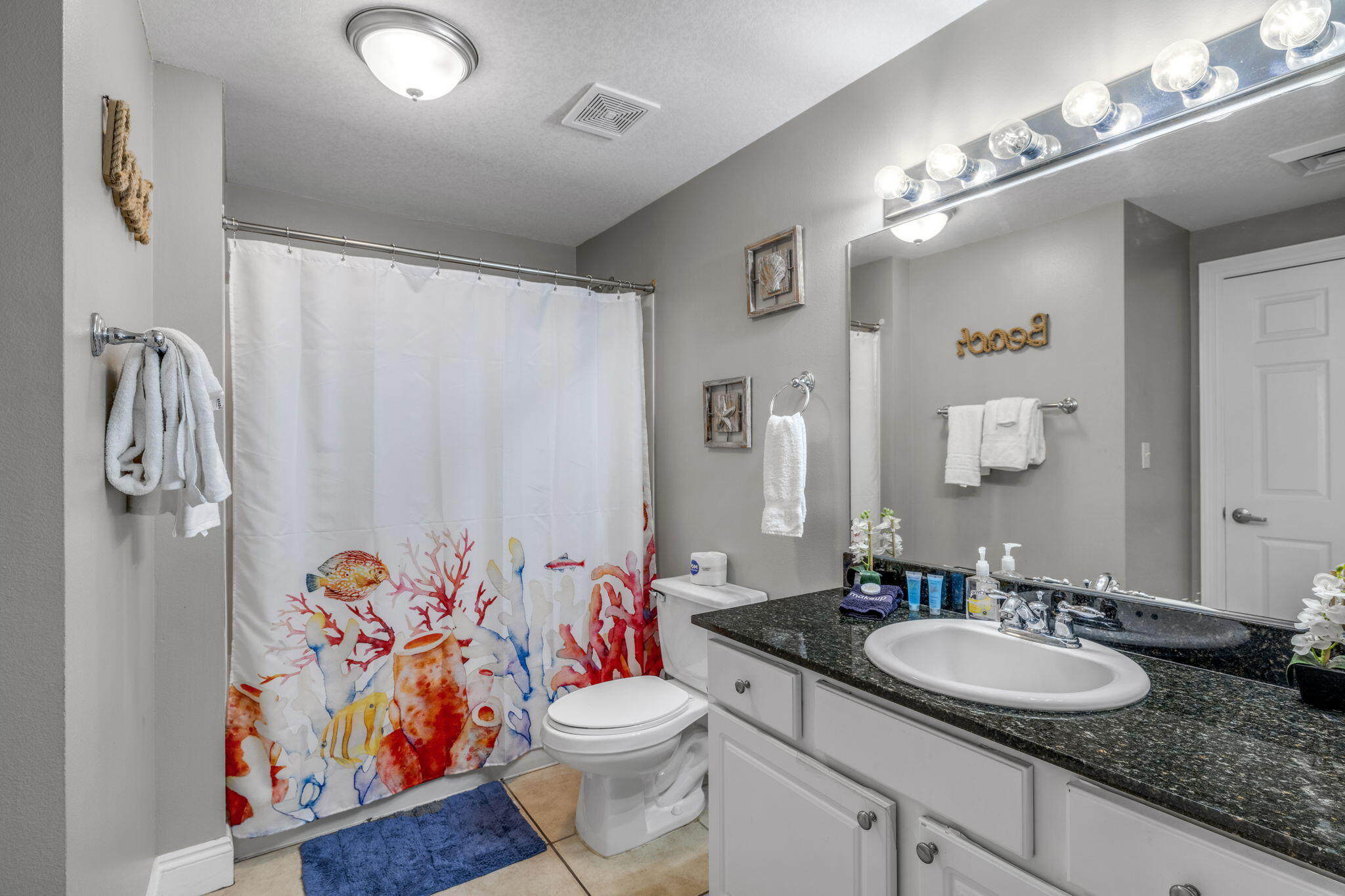 15817 Front Beach Road, Unit 21409 Panama City Beach, FL 32413 - Photo 14 of 23 a bathroom with a granite countertop sink a toilet and a mirror