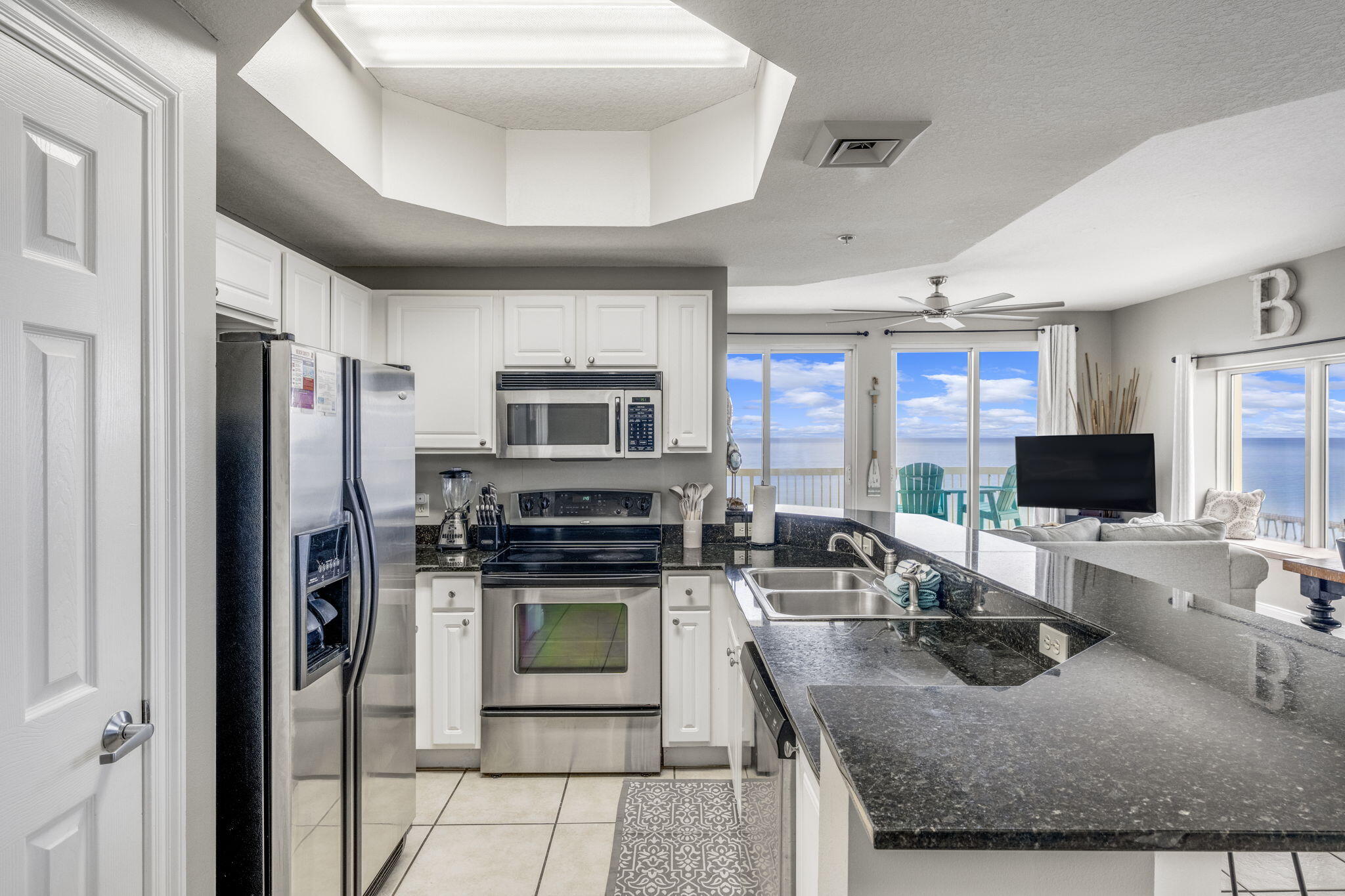 15817 Front Beach Road, Unit 21409 Panama City Beach, FL 32413 - Photo 5 of 23 a kitchen with stainless steel appliances granite countertop a stove refrigerator sink and microwave