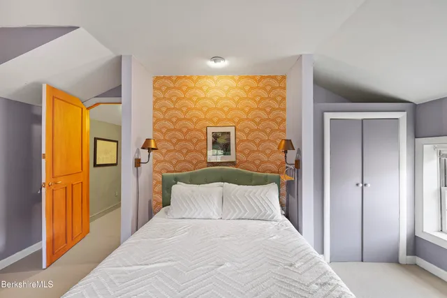 a bedroom with a bed and a lamp next to a window