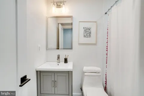 a bathroom with a toilet a sink and mirror