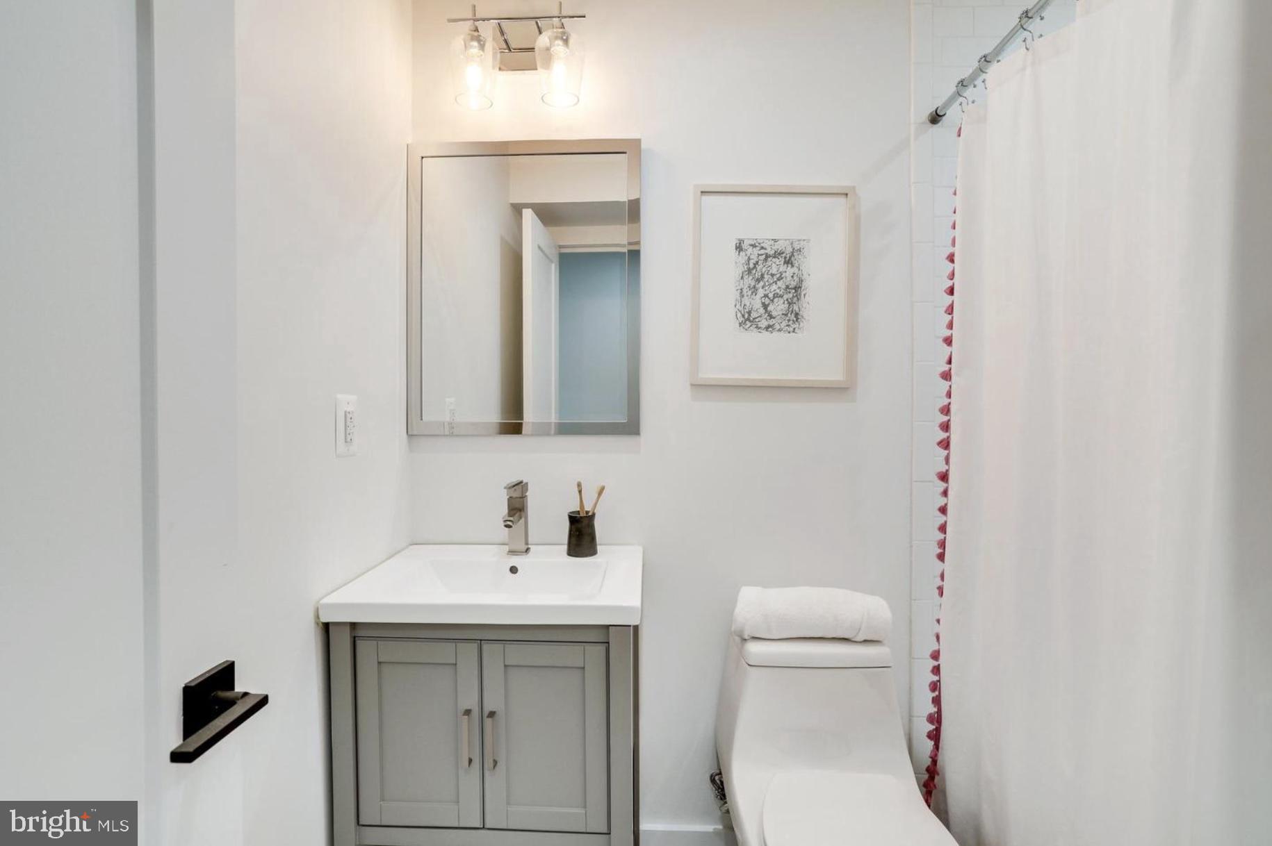 22 Bryant Street Northwest, Unit 1 Washington, DC 20001 - Photo 19 of 24 a bathroom with a toilet a sink and mirror