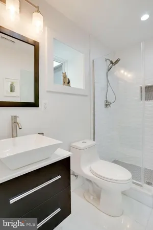 a bathroom with a sink a toilet and shower