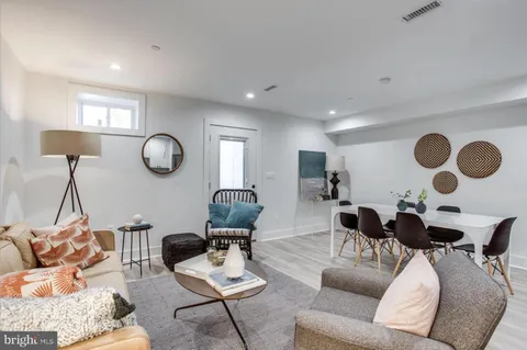 a living room with furniture and a mirror