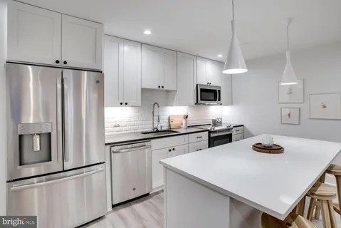 a kitchen with refrigerator and cabinets
