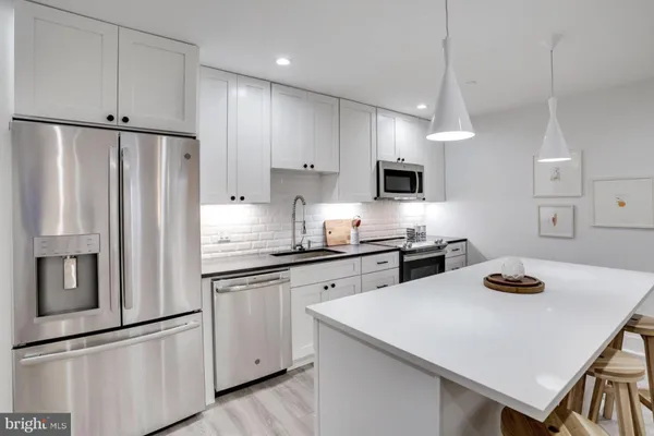 a kitchen with refrigerator and cabinets