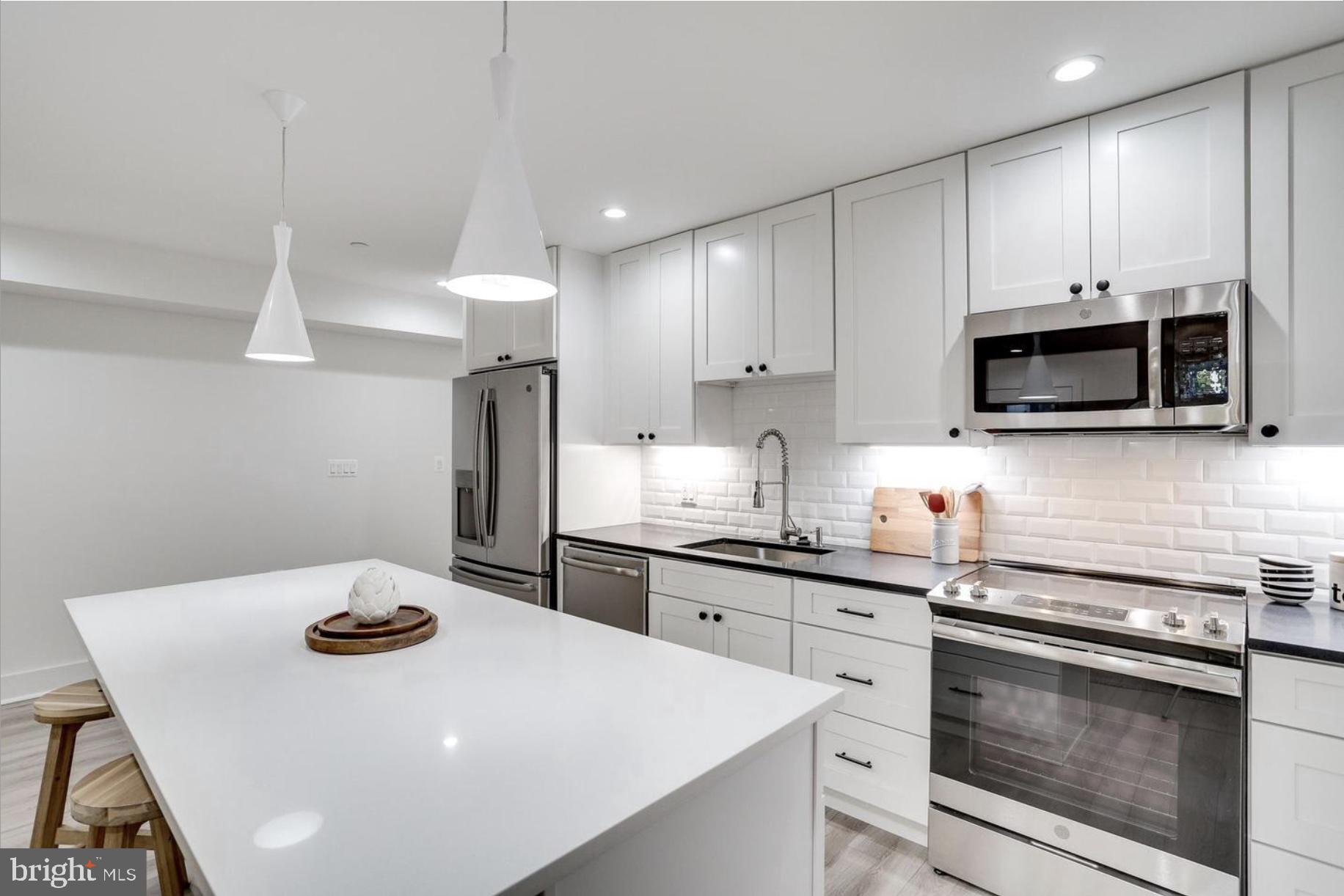 22 Bryant Street Northwest, Unit 1 Washington, DC 20001 - Photo 9 of 24 a kitchen with stainless steel appliances a stove a sink a microwave and cabinets