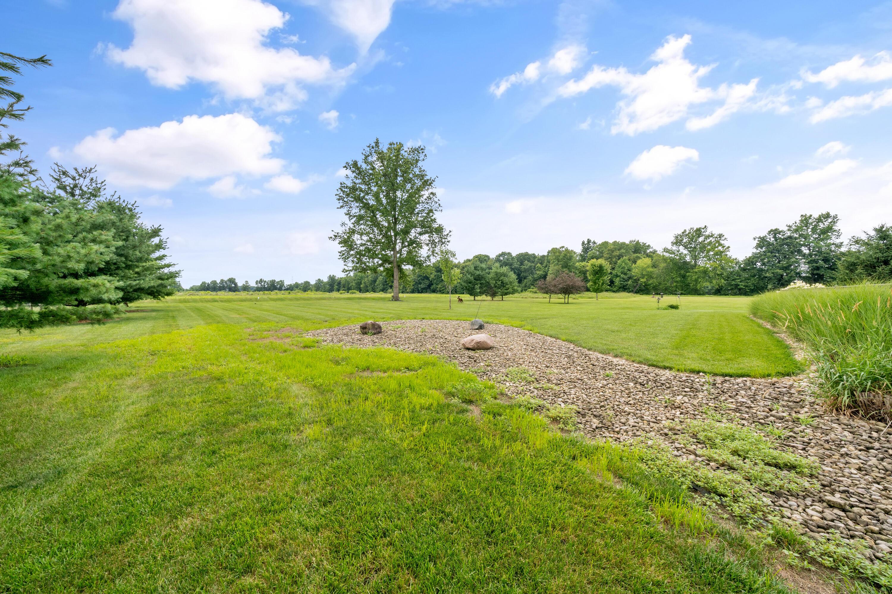 4640 Maynard Road Delaware, OH 43015 - Photo 83 of 91 Expansive green lawn with mature trees and a decorative rock bed