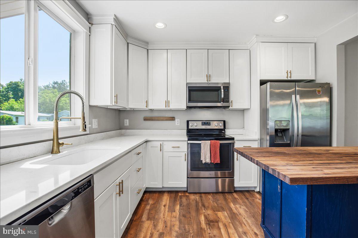 16146 Thomas Road Piney Point, MD 20674 - Photo 24 of 70 a kitchen with kitchen island granite countertop a sink stainless steel appliances and white cabinets