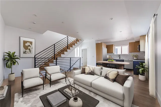 a living room with furniture kitchen view and a window