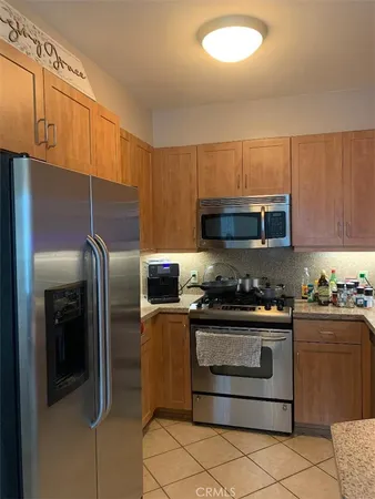 a kitchen with stainless steel appliances granite countertop a stove a refrigerator and a microwave