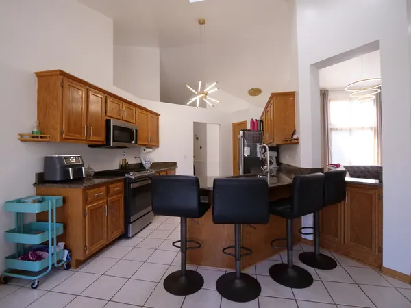 a kitchen with stainless steel appliances granite countertop a stove a sink dishwasher and a microwave with wooden floor