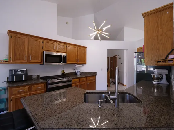 a kitchen with stainless steel appliances granite countertop a sink a stove and cabinets