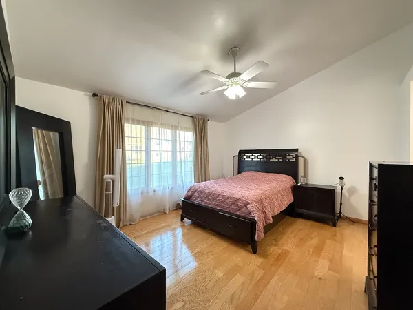 a bedroom with a bed dresser and a window