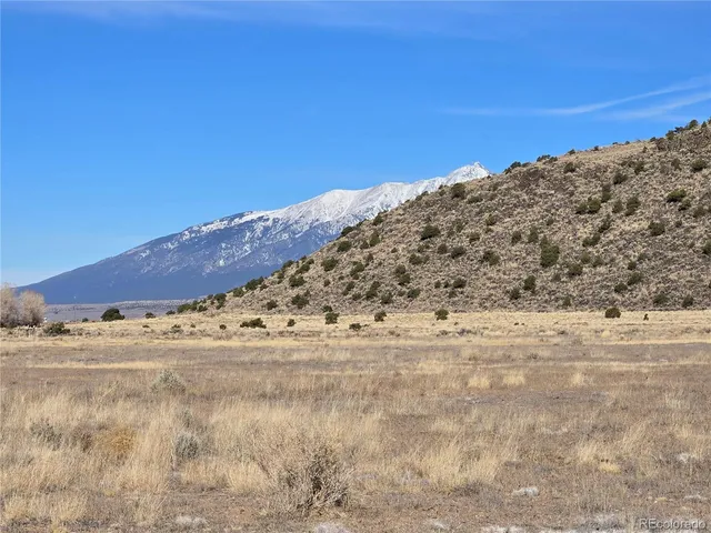a view of a field with a mountain in the background