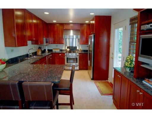 470 Uvedale Road Riverside, IL 60546 - Photo 3 of 12 a kitchen with stainless steel appliances kitchen island granite countertop a table chairs sink and cabinets