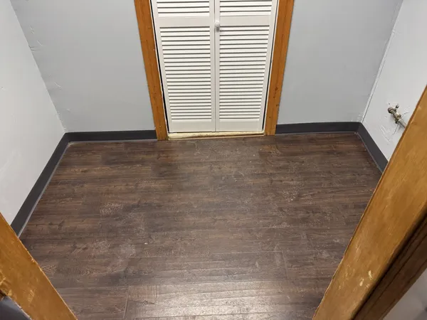 a view of a room with wooden floor and a window