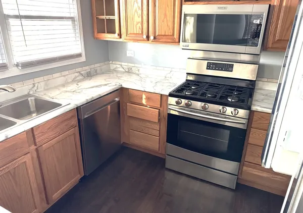 a kitchen with granite countertop cabinets stainless steel appliances and a sink