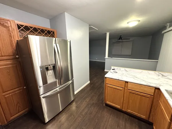 a kitchen with kitchen island a counter top space wooden floor and stainless steel appliances