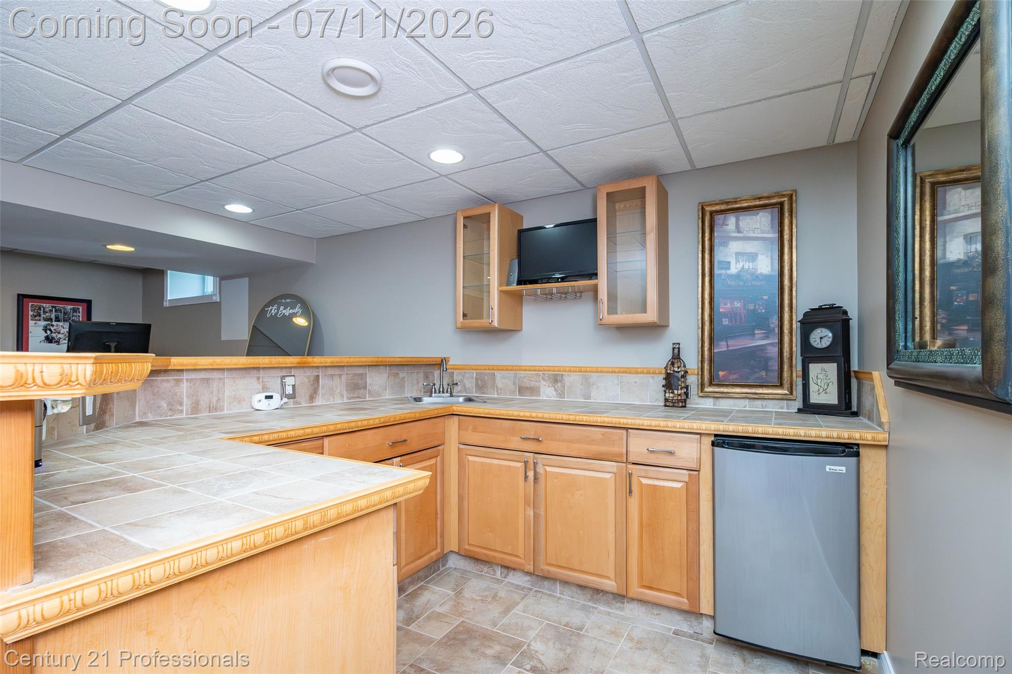 689 Woodfield Way Rochester, MI 48307 - Photo 38 of 61 Kitchenette featuring light wood cabinetry, a tile countertop, a tile backsplash, and an undermount sink
