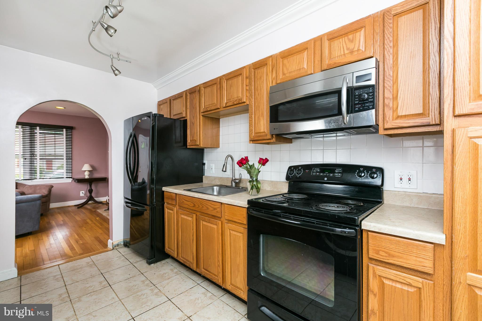 12712 Flack Street Silver Spring, MD 20906 - Photo 8 of 28 a kitchen with stainless steel appliances a stove a microwave and a sink