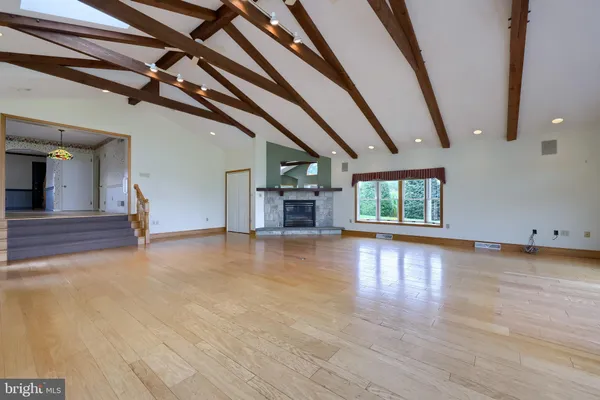 a view of empty room with wooden floor and bathroom
