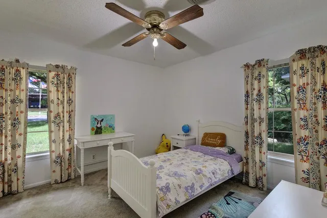 a bedroom with a bed a window and potted plant
