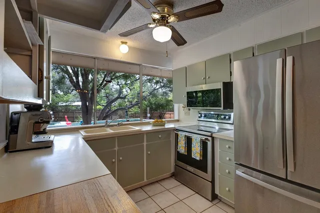 a kitchen with stainless steel appliances granite countertop a sink a stove and a refrigerator
