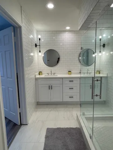 a bathroom with a double vanity sink a mirror and shower