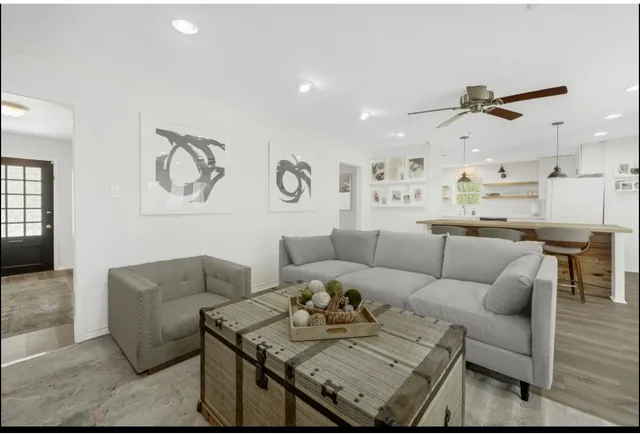 a living room with furniture kitchen view and a window