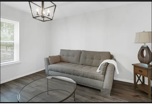 a living room with furniture a dining table and a window