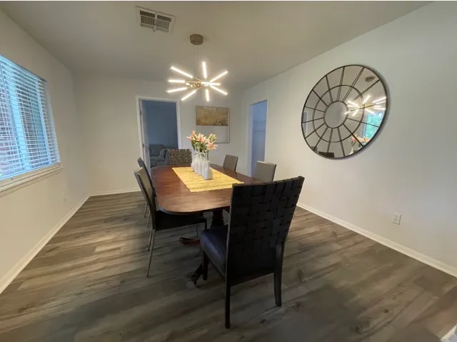 a view of a dining room with furniture wooden floor and a chandelier