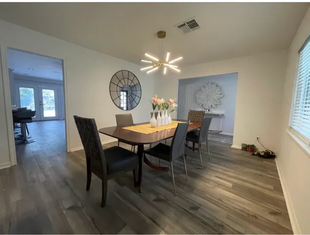 a view of a dining room with furniture a chandelier and wooden floor