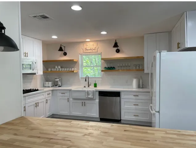 a kitchen with stainless steel appliances granite countertop a sink and cabinets