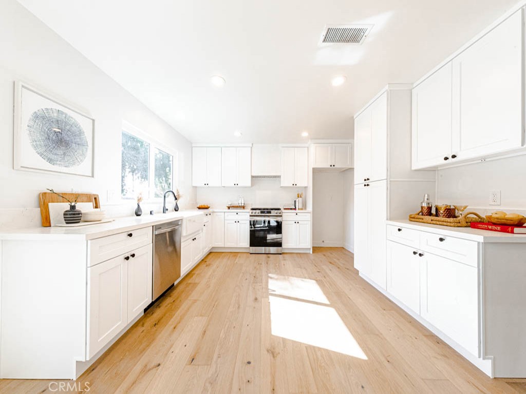 248 Crystal Lane Pasadena, CA 91103 - Photo 10 of 22 a large white kitchen with stainless steel appliances granite countertop a lot of counter space and wooden floors