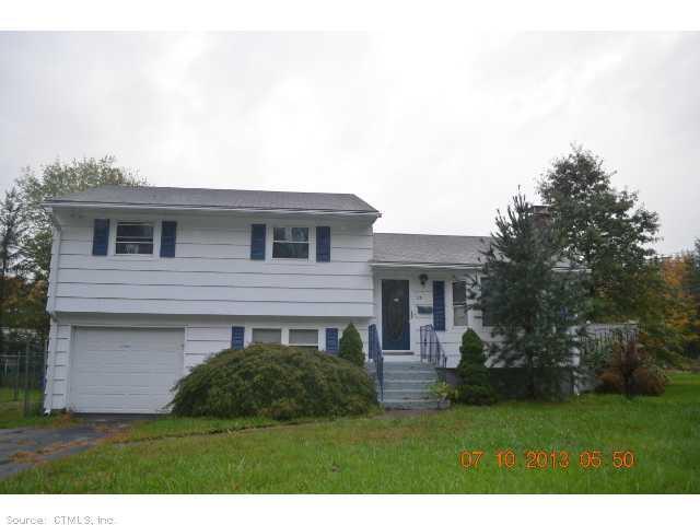 a view of a house with brick walls and a yard with plants