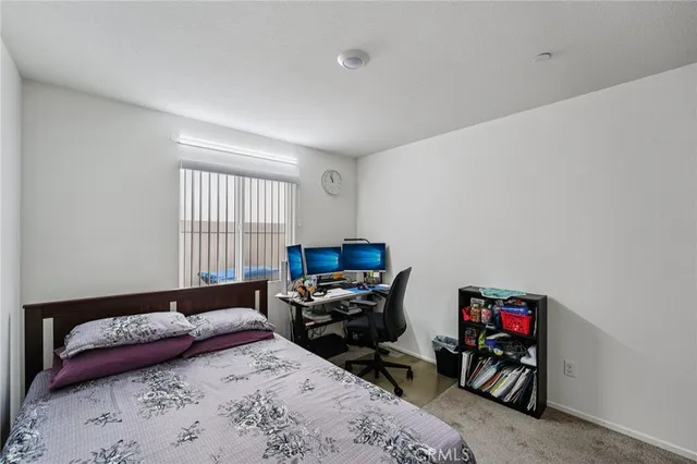 a bedroom with bed and a large window