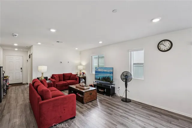 a living room with furniture and a wooden floor