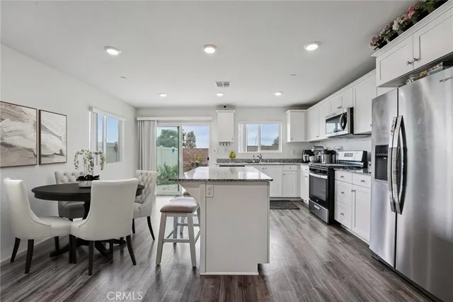 a kitchen with refrigerator a sink and chairs