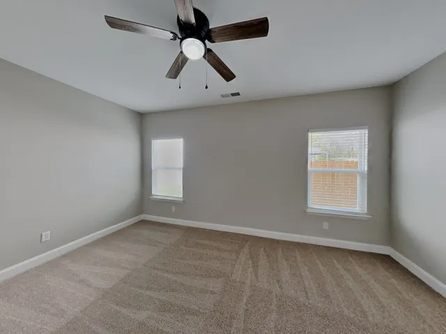 an empty room with a window and a fan