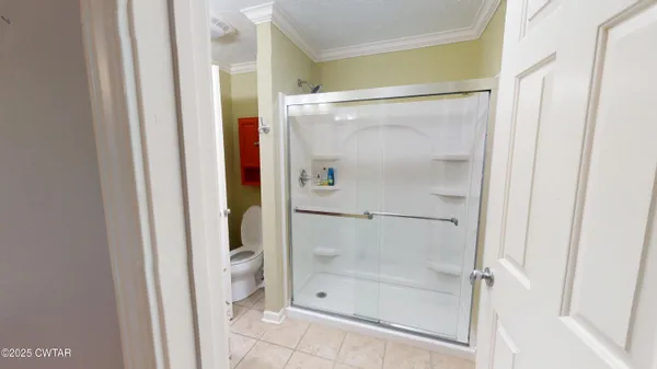 a view of an empty room with closet and a window