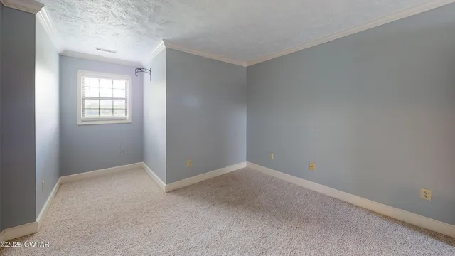 a view of an empty room with closet and a window